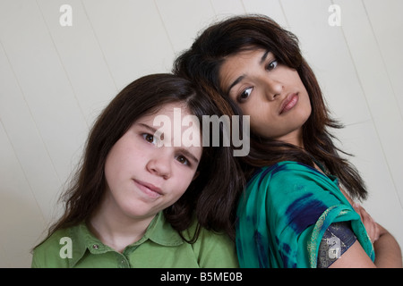 Junge indische Frau und ihrer preteen kaukasischen Stiefschwester posieren zusammen Modell veröffentlicht Stockfoto