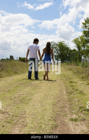 Ein paar hinunter eine unbefestigte Straße Hand in Hand Stockfoto