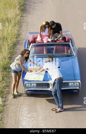 Zwei Paare und ein Auto hielt am Straßenrand Stockfoto