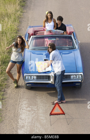 Zwei Paare und ein Auto hielt am Straßenrand Stockfoto