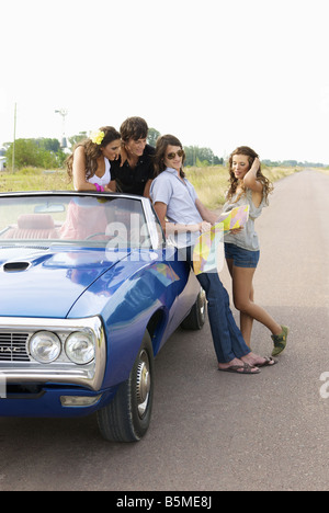 Zwei Paare und ein Auto hielt am Straßenrand Stockfoto