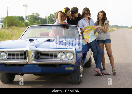 Zwei Paare und ein Auto hielt am Straßenrand Stockfoto