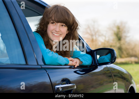 Junge Frau aus Auto lächelnd Fenster gelehnt Stockfoto