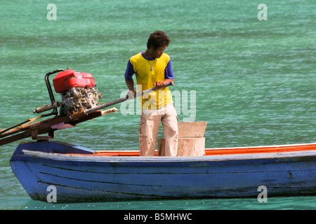 junger Mann Segeln Longtail-Boot auf die Andamanensee, Nationalpark Mu Ko Surin, thailand Stockfoto