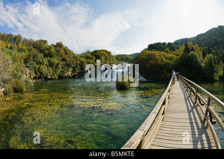 Touristen auf Holzsteg Boards am Skradinski Buk Wasserfall auf dem Fluss Krka in Herbstsonne Krka Kroatien suchen Stockfoto