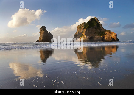 Torbogen Inseln Reflected in feuchten Sand von Wharariki Beach in der Nähe von Cape Farewell North West Nelson Region Südinsel Neuseeland Stockfoto