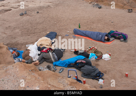 Gruppe von spanischen Jugendlichen, die after-Party am Strand schlafen. Viele leere Bierdosen am Strand Stockfoto