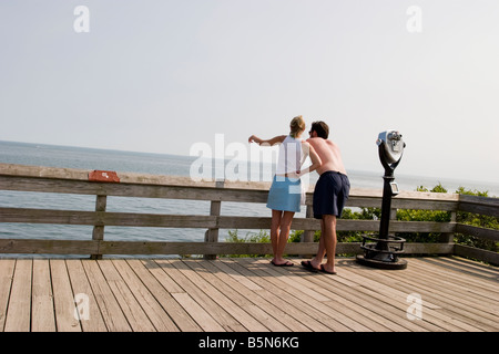 Junges Paar auf der Promenade am Strand, mit die junge Frau zeigte Stockfoto