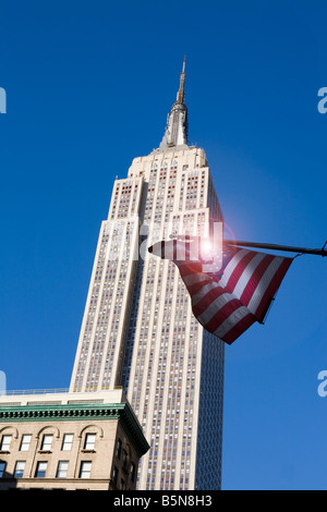 Das Empire State Building mit Sternen und Streifen fliegen im Wind, Fifth Avenue New York City USA Stockfoto