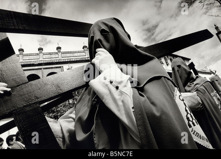 Vermummte Mitglieder der Bruderschaft tragen Kreuze während der Prozessionen der Semana Santa in Sevilla. Spanien Stockfoto