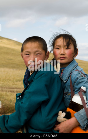 Geschwister fahren ihr Pferd zusammen in den mongolischen Steppen. Stockfoto