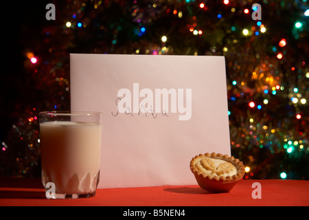 Kinder-Brief an den Weihnachtsmann am Heiligabend mit Mince Pie und ein Glas Milch vor Weihnachten Baum ausgelassen Stockfoto