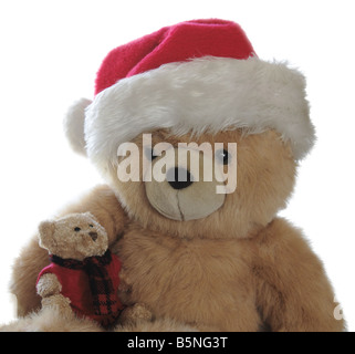 großer Teddybär mit Santa Hut mit einem kleinen Bären in seinem Schoß Stockfoto