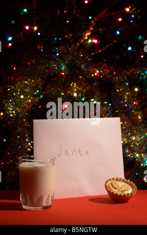 Kinder-Brief an den Weihnachtsmann am Heiligabend mit Mince Pie und ein Glas Milch vor Weihnachten Baum ausgelassen Stockfoto