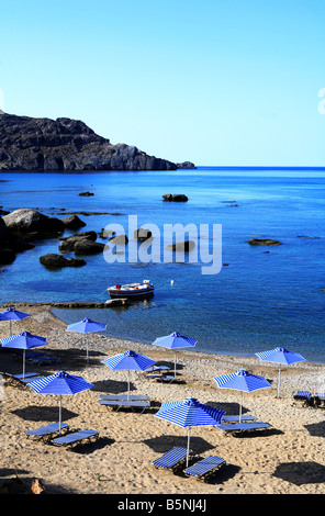 Sonne-Sonnenschirme, Sonnenliegen und einem kleinen Fischerboot auf der westlichen Seite von Plakias südlichen Kreta Griechenland Stockfoto