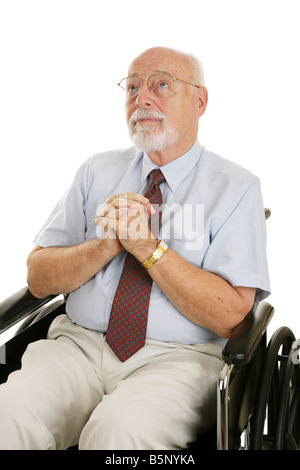 Älteren Mann in einem Rollstuhl mit seinen Händen gefaltet im Gebet isoliert auf weiß Stockfoto