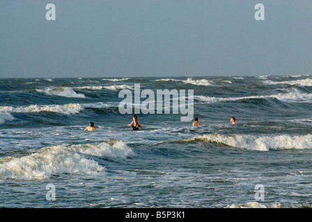 Menschen schwimmen an Seawall Boulevard Strand bei Sonnenaufgang in Galveston Texas USA Stockfoto