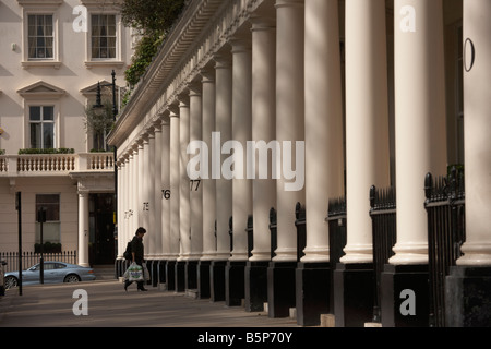 Bewohner kommt nach Hause unter makellos dorischen Säulen der klassischen viktorianischen Eigenschaften in Eaton Square Belgravia SW1 Stockfoto