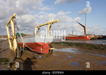 Kleine hölzerne Fischerboot in einer Wiege bereit zum Start nach Antifouling Farbe wurde angewendet Pin Mill Suffolk Stockfoto