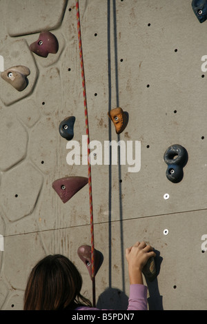 Person auf künstliche Kletterwand im Freien in der Sonne Stockfoto