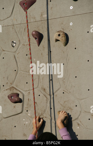 Person auf künstliche Kletterwand im Freien in der Sonne Stockfoto