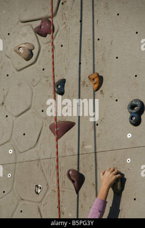 Person auf künstliche Kletterwand im Freien in der Sonne Stockfoto