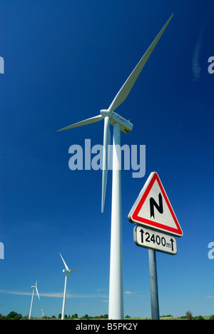 Kurven voraus Straßenschild in der Nähe einer Windfarm auf blauen Himmel - Frankreich Stockfoto