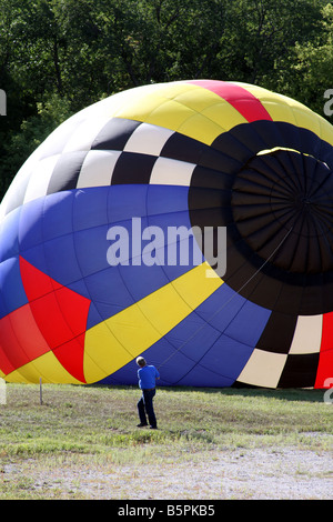Ein Heißluftballon steigen mit Heißluft und geleitet von einem Mann der Sicherheit Stockfoto