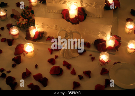 Eine ausgefallene Hochzeitstorte mit Kerzen brennen um den Kuchen für eine Hochzeitsfeier angezeigt Stockfoto