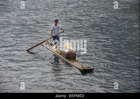 Chinesische Souvenir-Verkäufer paddeln seine Bambus-Floß auf der Suche nach Touristen auf dem Li-Fluss Lijang in Yangshuo, in der Nähe von Guilin, China Stockfoto