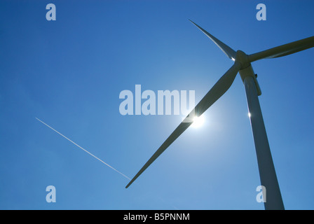 Eine horizontale Bild von einer Windturbine mit einer Rauch Spur von Verkehrsflugzeug in einen am blauen Himmel - Frankreich Stockfoto