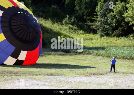 Ein Heißluftballon steigen mit Heißluft und geleitet von einem Mann der Sicherheit Stockfoto