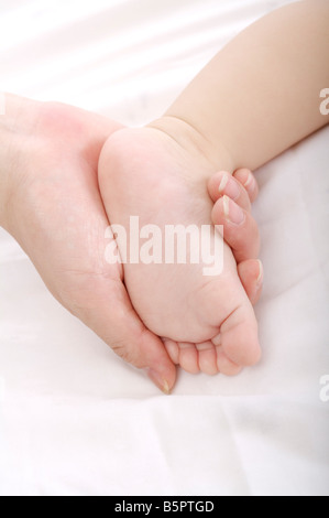 Mutter mit einem Baby Fuß in der hand Stockfoto