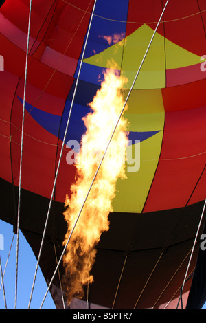 Die Flammen des Brenners erwärmen eine Multi farbige Hot Air Balloon Stockfoto