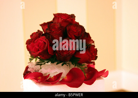 Eine ausgefallene Hochzeitstorte mit roten Rosen an der Spitze angezeigt für eine Hochzeitsfeier Stockfoto