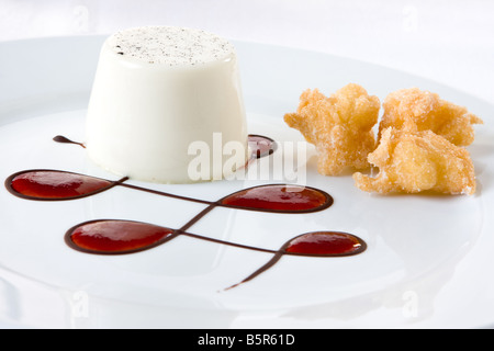 Edel Dessert mit Vanille Pudding, Krapfen und Erdbeersauce in Schokolade Linien Stockfoto