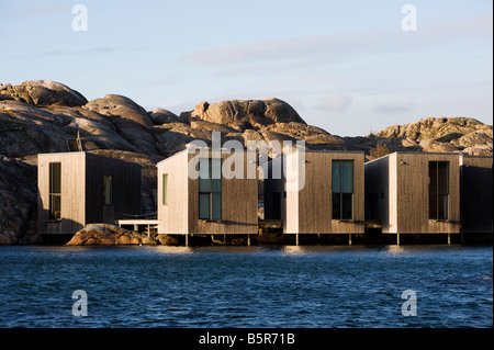 Moderne Ferienhütten aus Holz, die am Meer gegenüber dem Nordic Watercolor Museum in Skarhamn an der Bohuslan-Küste in Schweden errichtet wurden Stockfoto