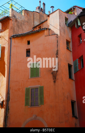 Verschiedene Fenster mit grünen Fensterläden auf rötlichen Wand, dichten Aufbau, alten Ortsteil Südstadt, Blick von unten Stockfoto