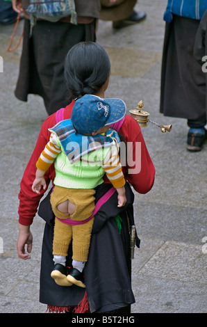 Baby auf dem Rücken in der traditionellen tibetischen Mode getragen. Lhasa, Tibet Stockfoto