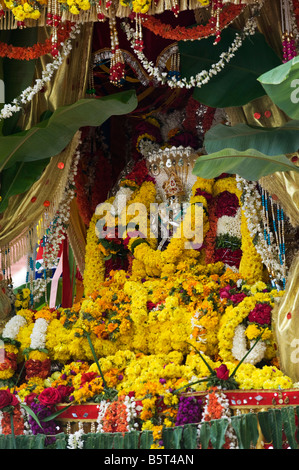 Lord Krishna Silberstatuen bekränzt an ein Hindu fest.  Puttaparthi, Andhra Pradesh, Indien Stockfoto