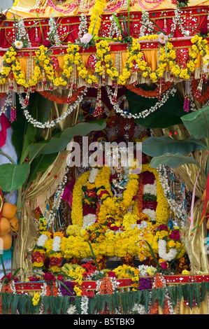 Lord Krishna Silberstatuen bekränzt an ein Hindu fest.  Puttaparthi, Andhra Pradesh, Indien Stockfoto