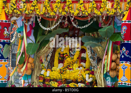 Lord Krishna Silberstatuen bekränzt an ein Hindu fest.  Puttaparthi, Andhra Pradesh, Indien Stockfoto