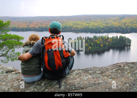 Eltern und Kind sitzen auf Klippe, die malerische Aussicht genießen Stockfoto