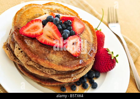 Stapel von Buchweizen Pfannkuchen mit frischen Beeren und Ahornsirup Stockfoto