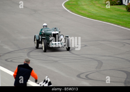 Ein Marshall Wellen die Zielflagge als ein 1930 Lea Francis Hyper Replikat das Finish in VSCC Herbst Sprint Goodwood überquert Stockfoto