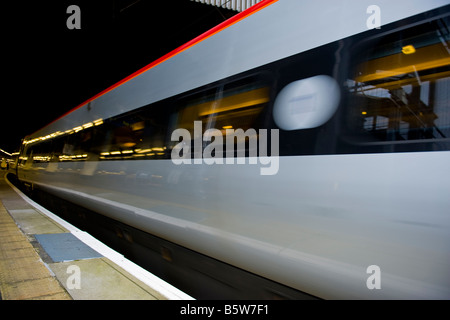 London, Euston Bahnhof, Virgin Rail Eisenbahnwagen Zug oder Wagen beschleunigen von Plattform in einer Unschärfe Stockfoto