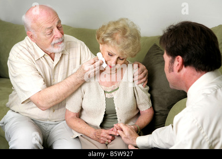 Ein älteres Paar mit einem Berater oder Bestatter sie weint und sie sind ihr beruhigend Stockfoto