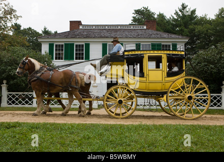 Eine Pferdekutsche Postkutsche führt Besucher vorbei an der Salem Town House, Old Sturbridge Village (OSV), Massachusetts Stockfoto