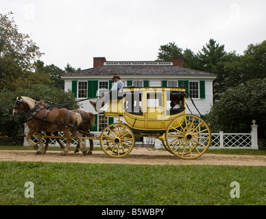 Eine Pferdekutsche Postkutsche führt Besucher vorbei an der Salem Town House, Old Sturbridge Village (OSV), Massachusetts Stockfoto