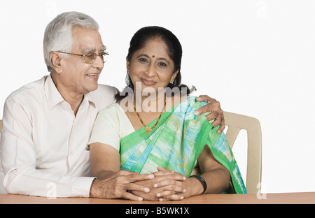 Ältere Mann sitzt mit seinen Arm um eine reife Frau Stockfoto
